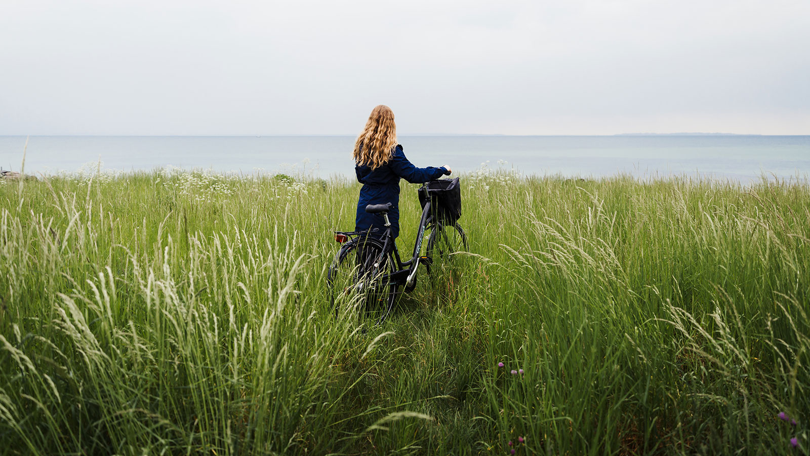 Kvinde med cykel ved Nordkyststien