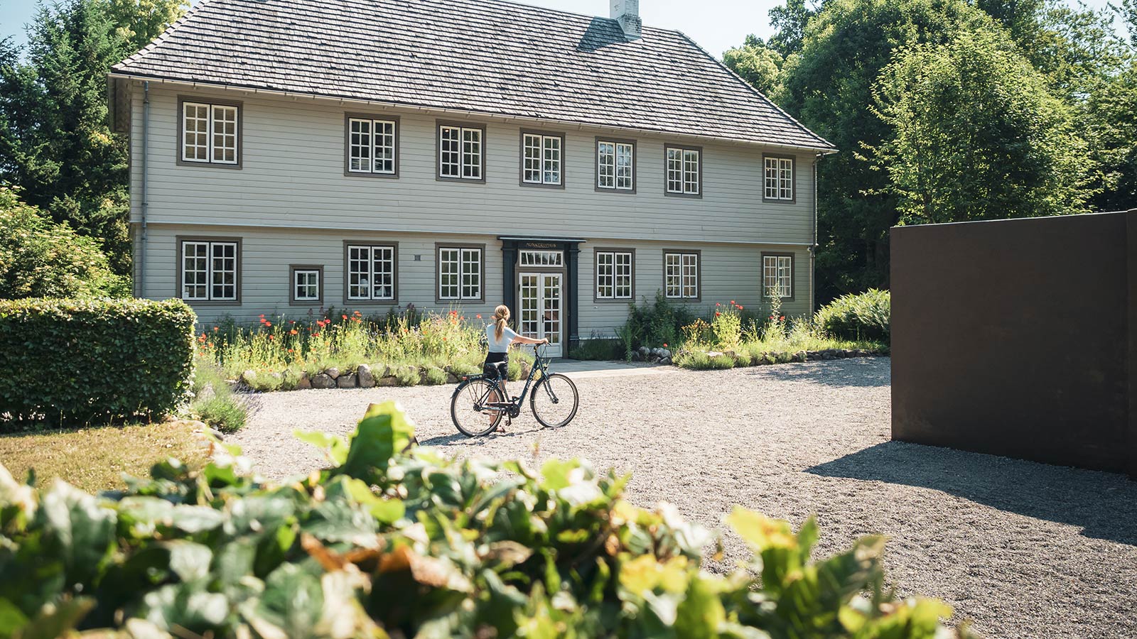 Kvinde med cykel ved Munkeruphus